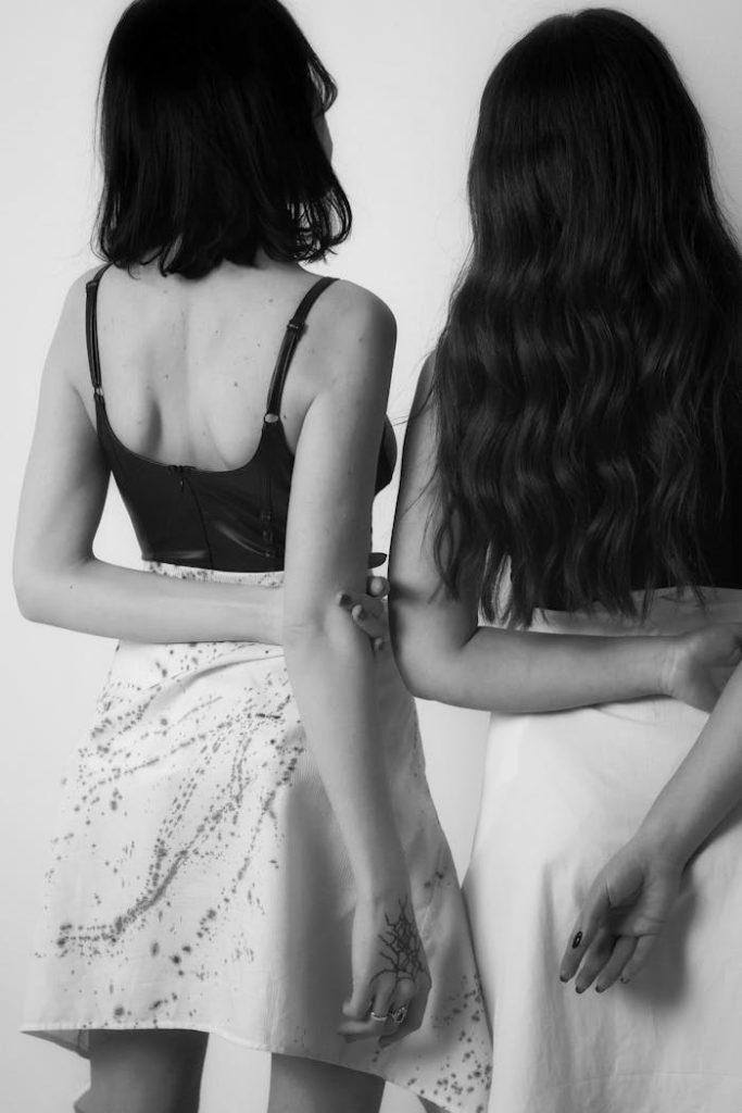 Elegant black and white portrait capturing the intimacy and connection between two women from behind.